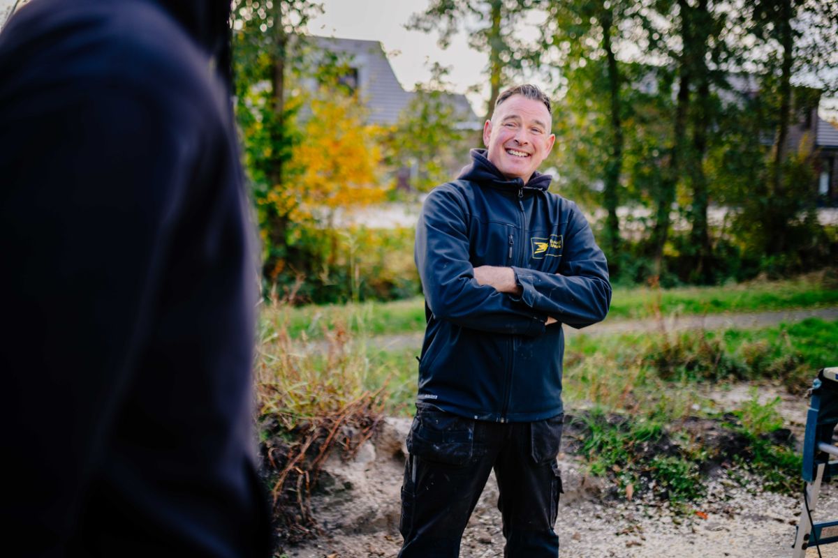 Medewerker van U. Veenstra staat ontspannen op de bouwlocatie