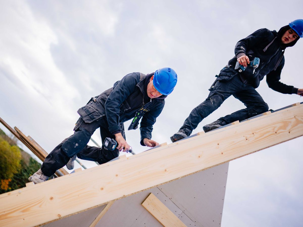 Timmermannen van U. Veenstra werken samen aan het plaatsen van een houtskeletbouwelement
