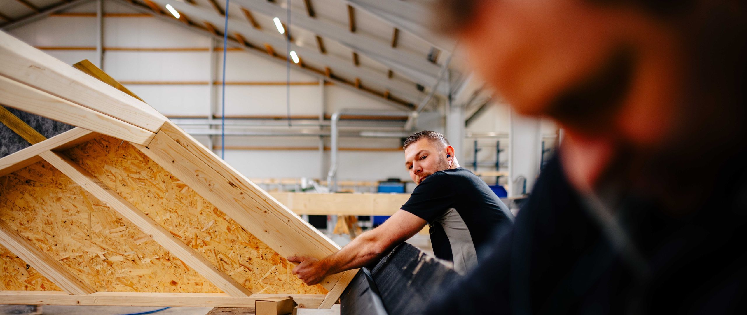 U. Veenstra medewerker assembleert houten dakelement in de werkplaats