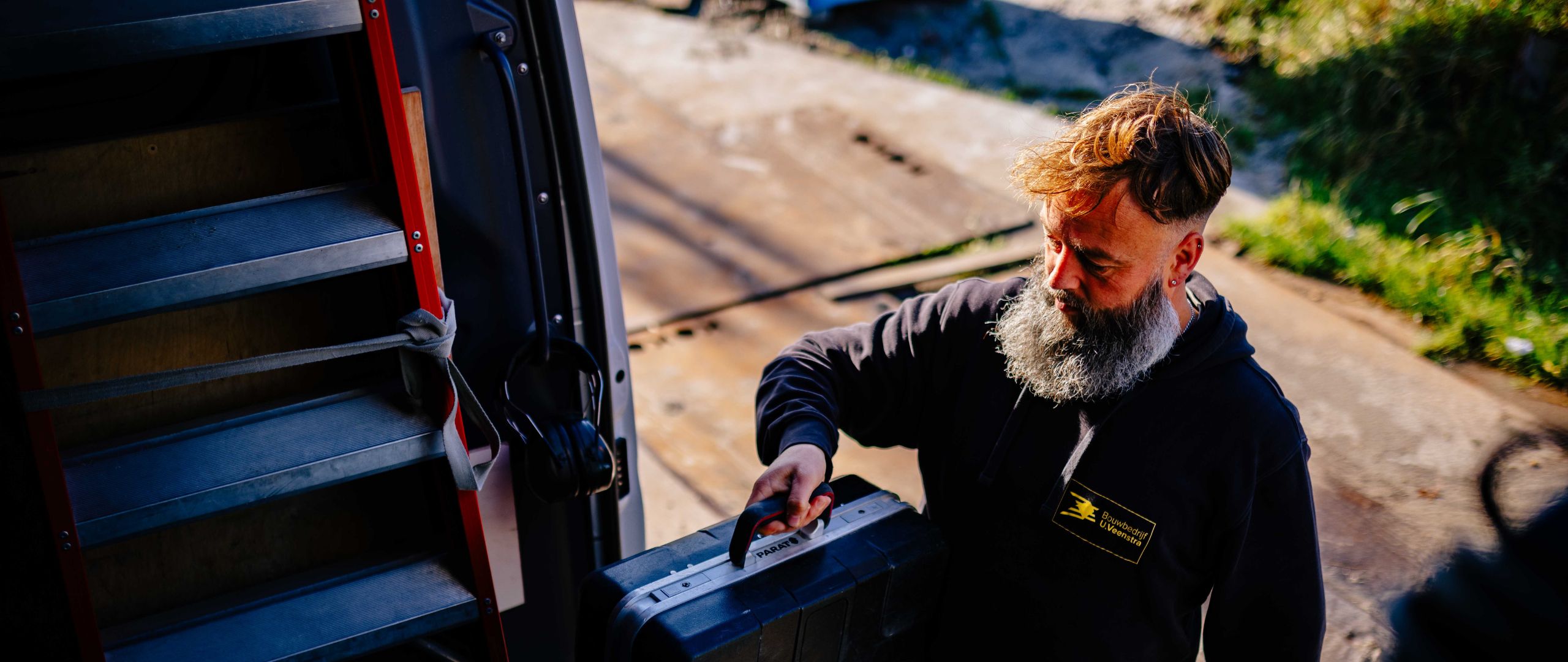 Vakman van U. Veenstra pakt gereedschap uit de werkbus