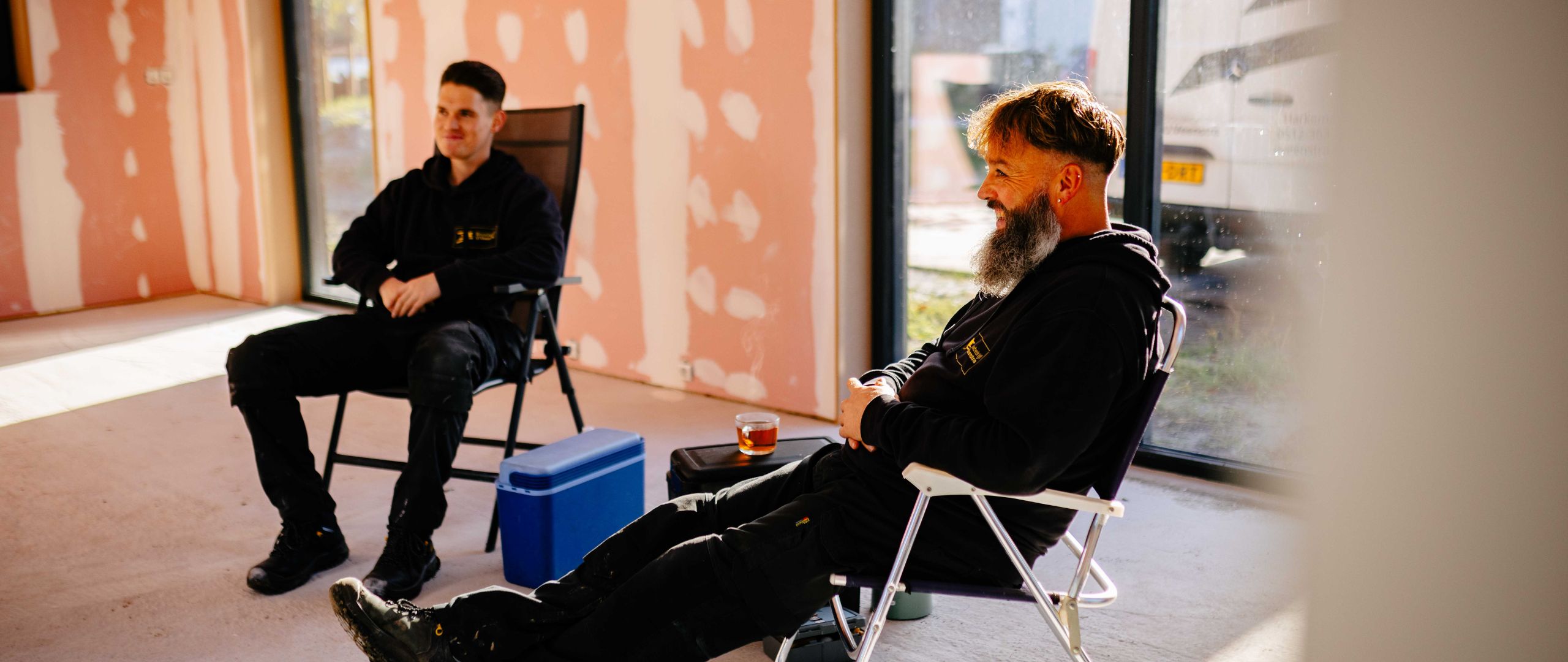 2 medewerkers zitten op een stoel in de woning