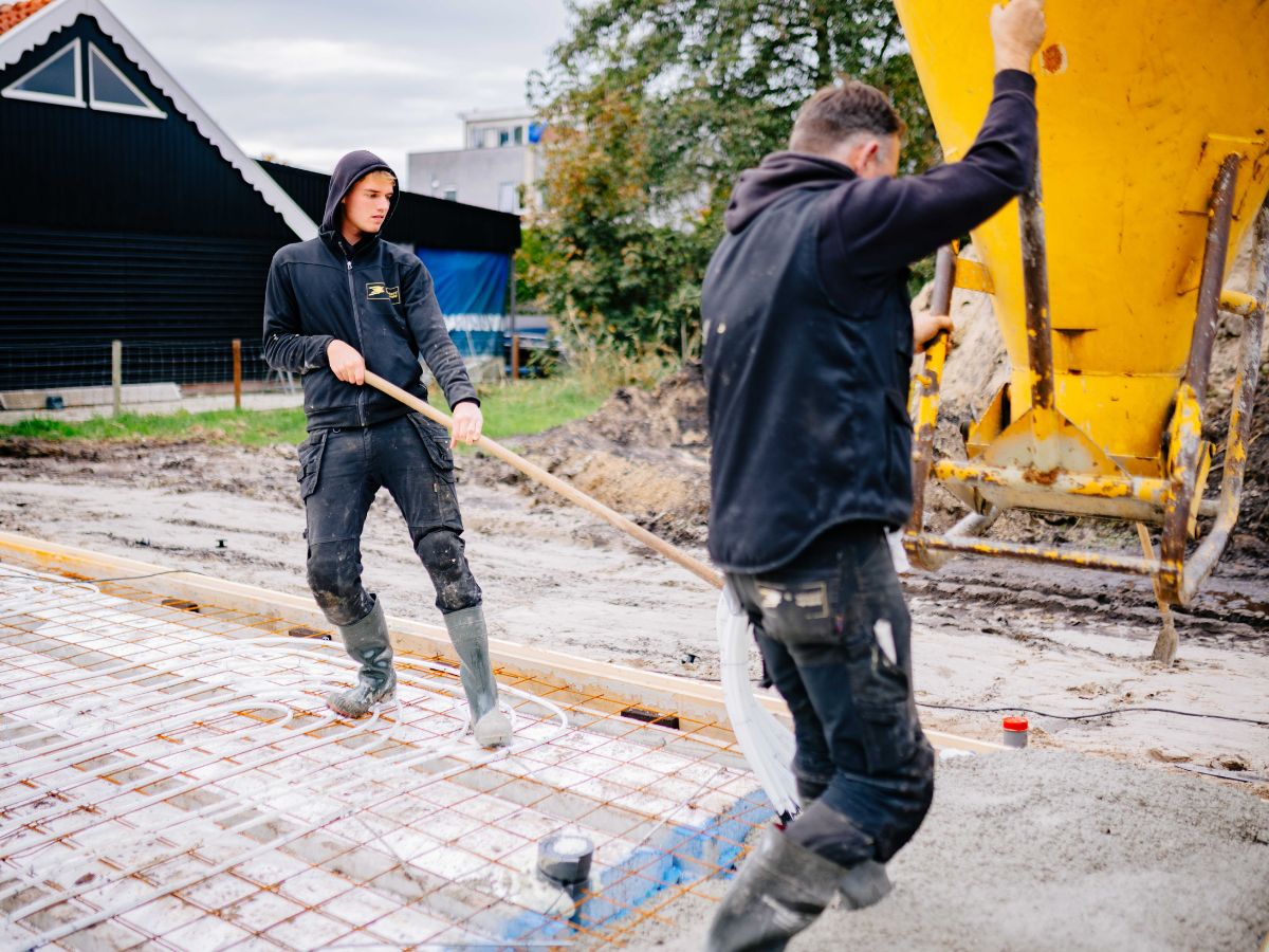 Collega\'s verdelen beton bij het storten