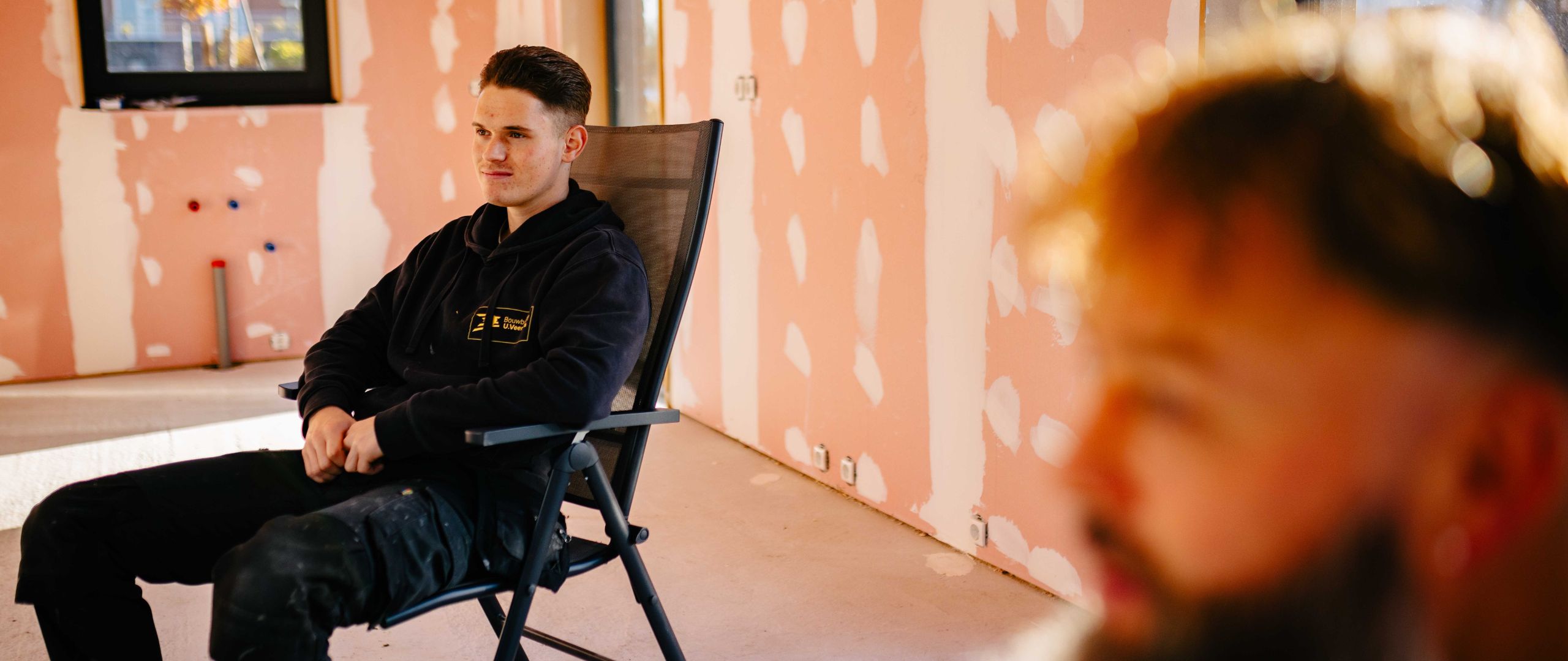 Installatiemonteur zit op een stoel in een huis