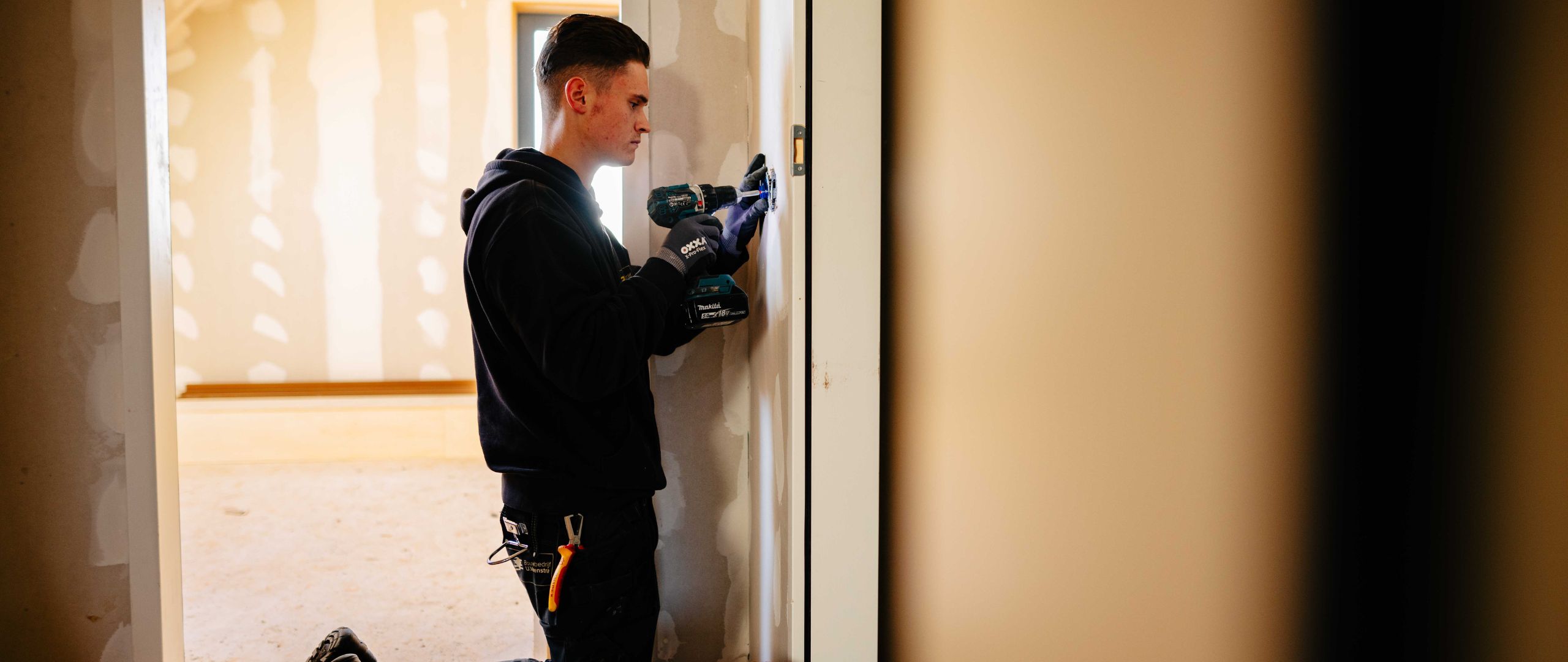 Medewerker installeert stopcontacten in een huis geconcentreerd