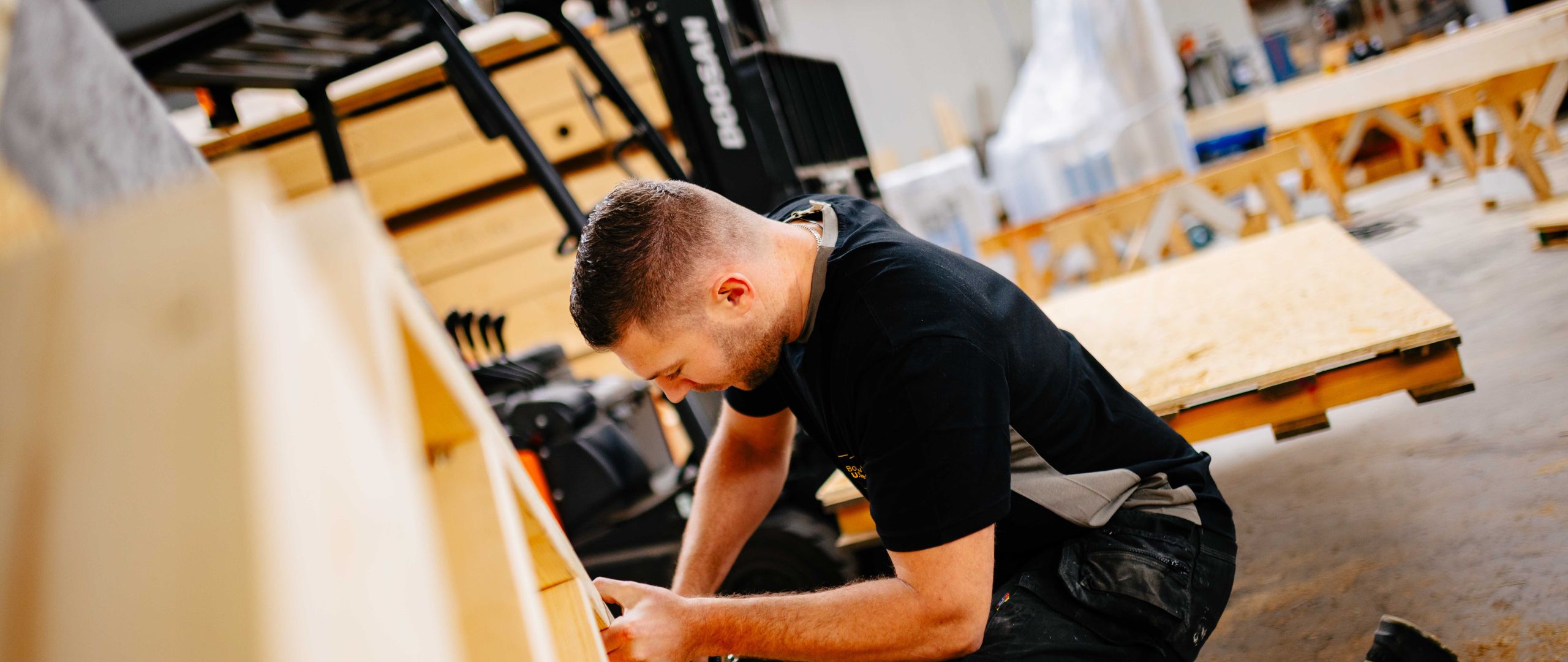 Medewerker van U. Veenstra werkt geconcentreerd in de timmerwerkplaats