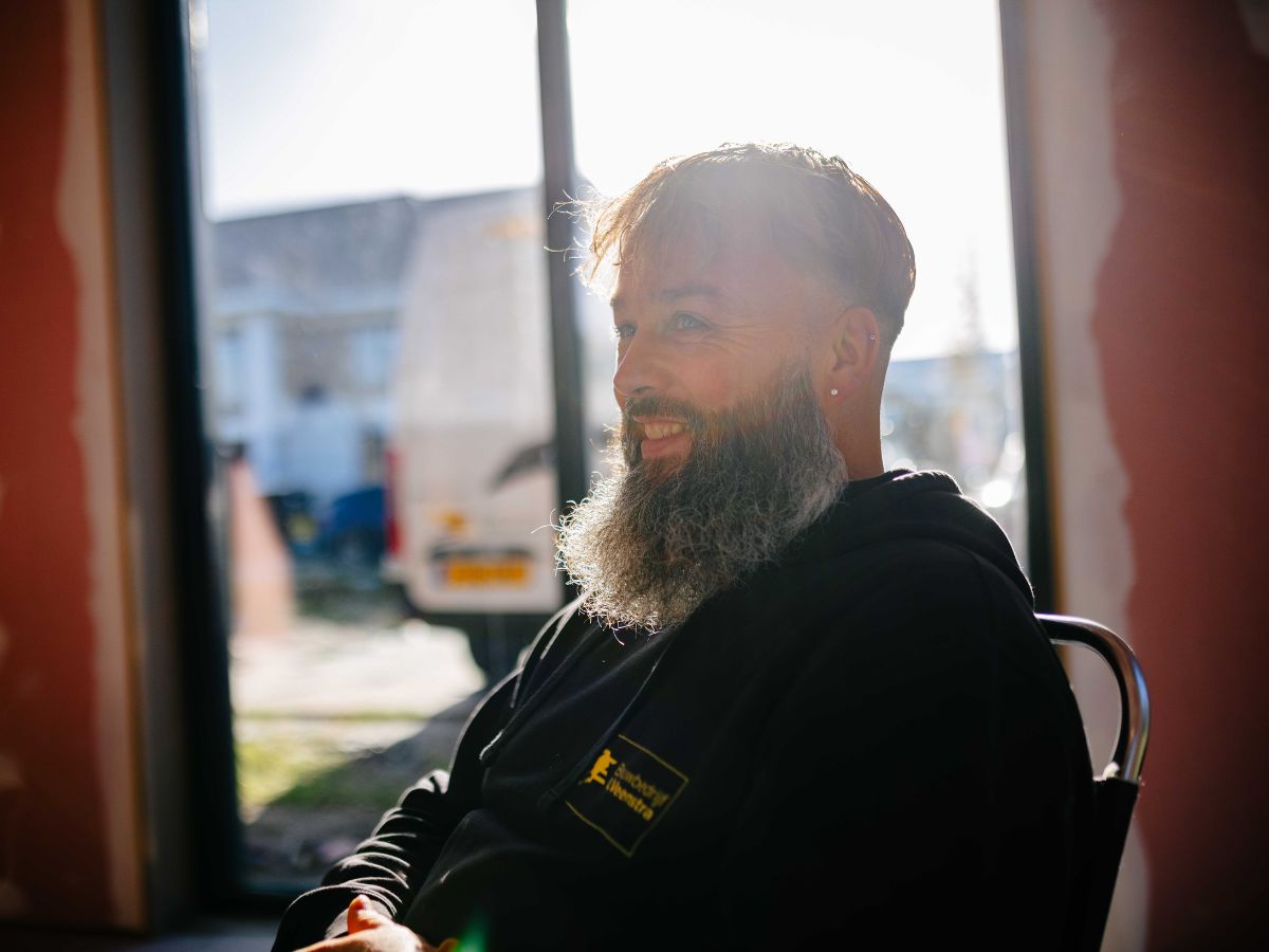 U Veenstra vakman poseert bij raamopening