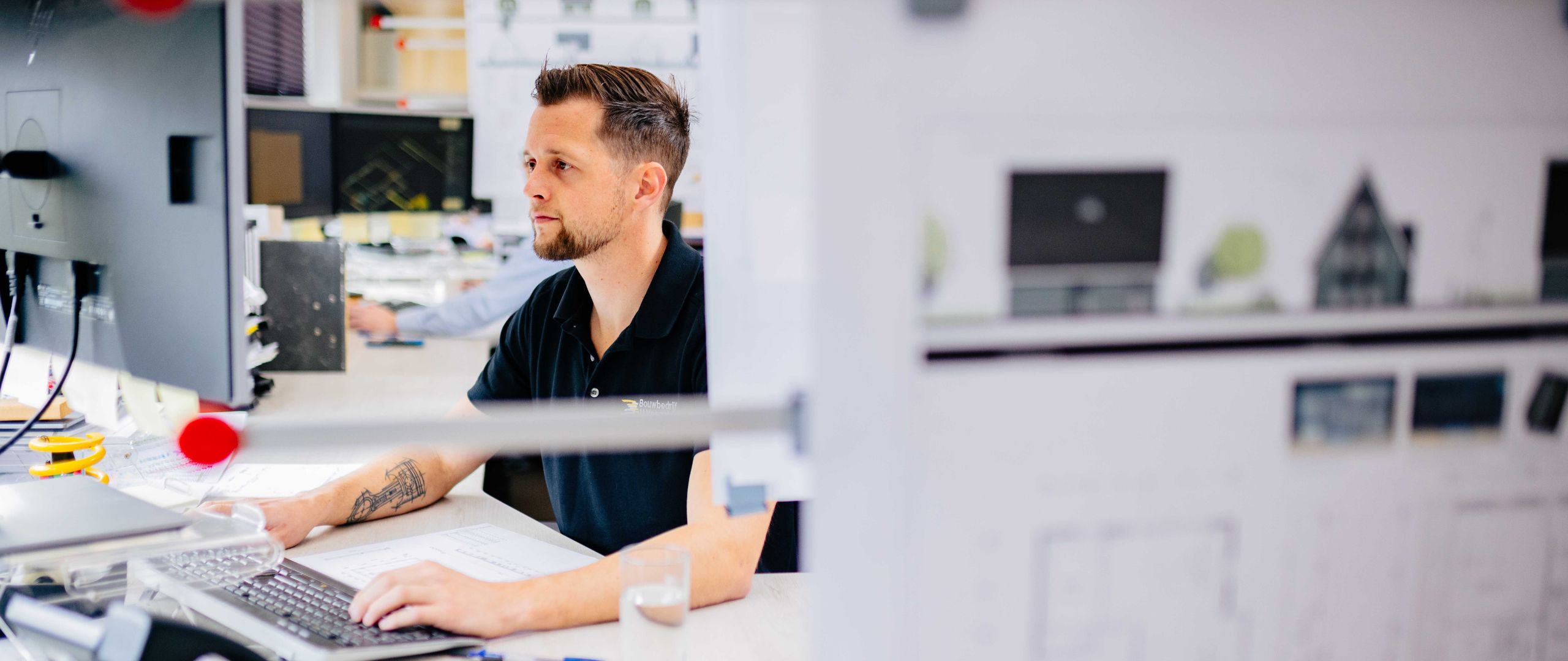U. Veenstra medewerker werkt geconcentreerd achter computer op kantoor