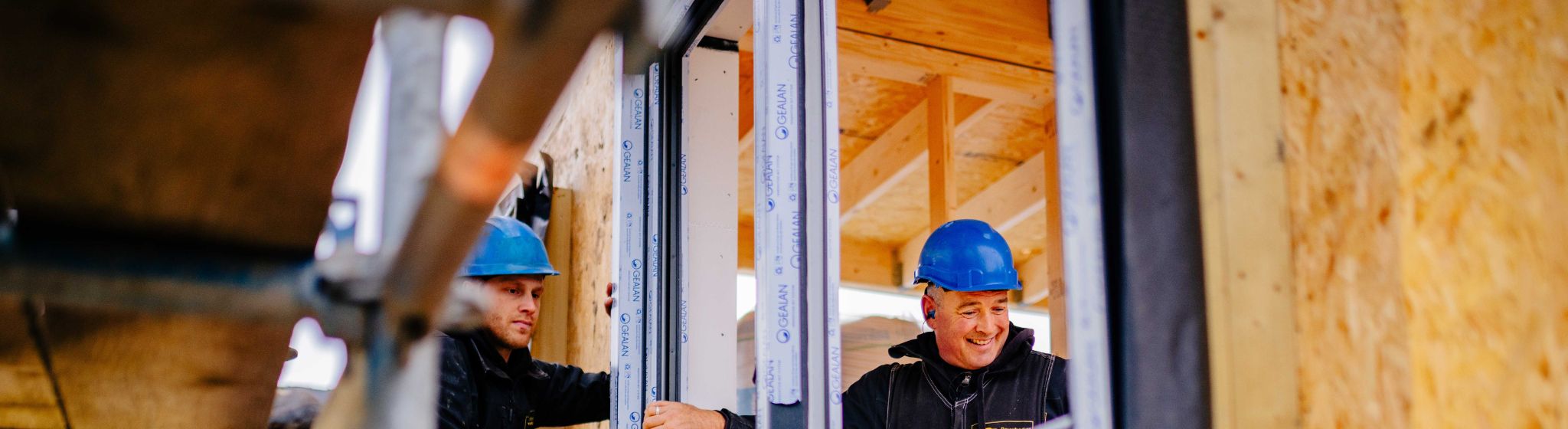 U. Veenstra monteurs plaatsen kozijn in prefab woning.