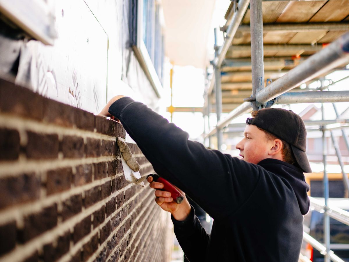 U. Veenstra vakman metselt muur