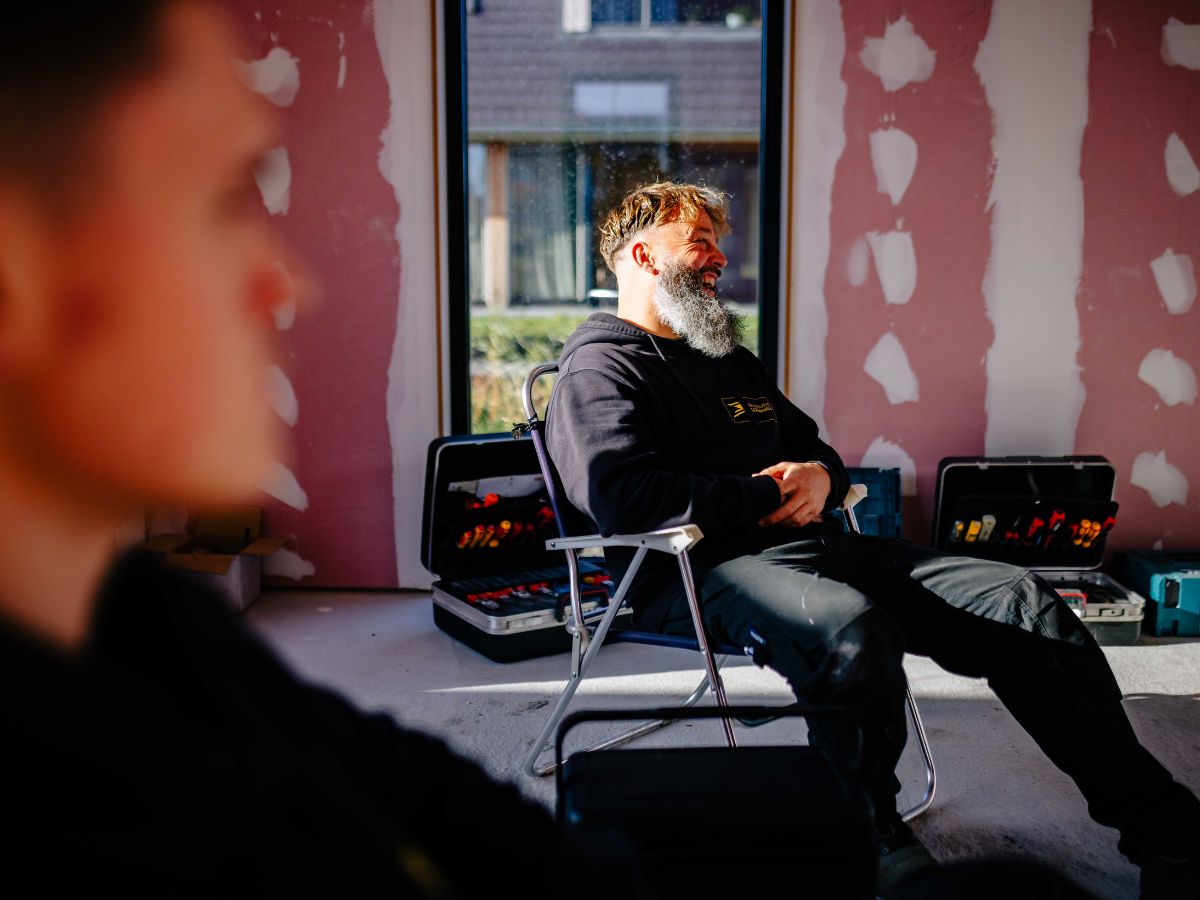 Vakman neemt pauze in een woning in aanbouw